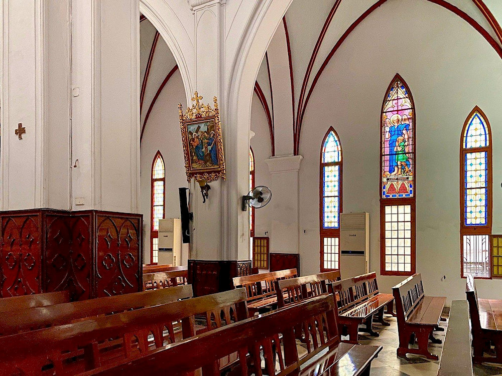 Inside the cathedral, warm light filters through stained glass, filling the space with quiet beauty